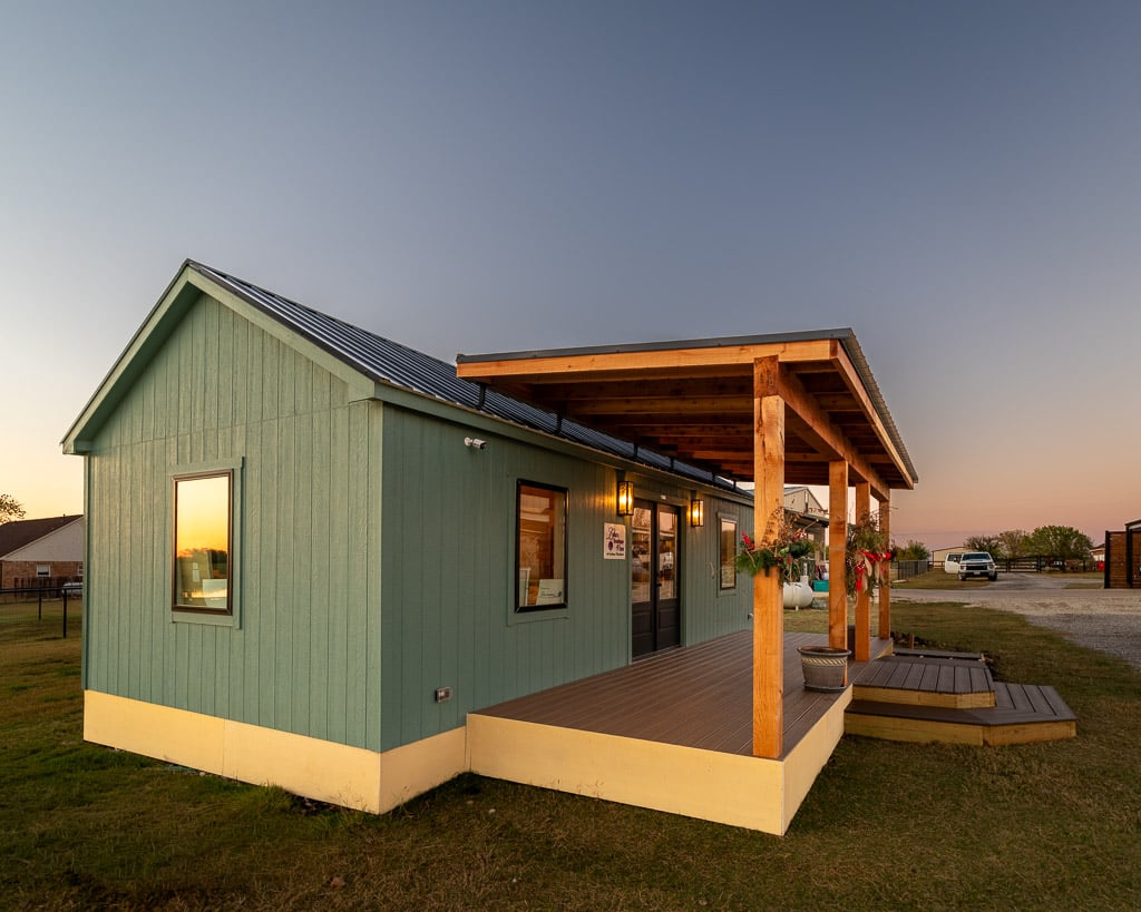 The Goshen Meadows cabin shell from the front corner, showing the LP SmartSide siding, gable end and black metal roof